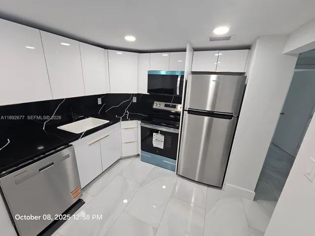 a kitchen with a sink and white cabinets