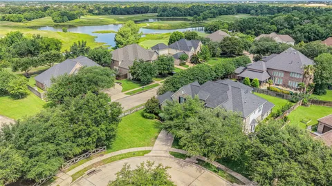 an aerial view of lake residential house with outdoor space and swimming pool