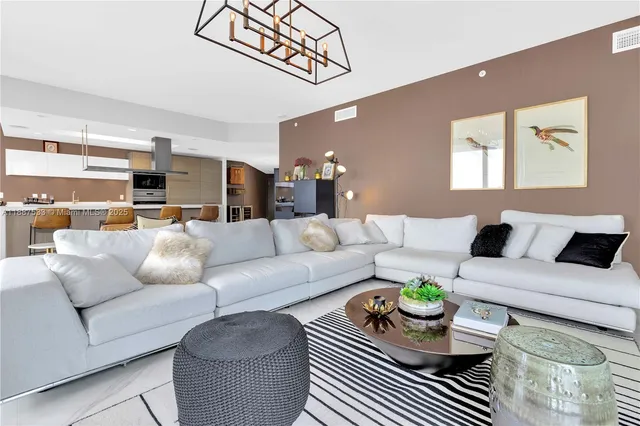 a living room with furniture and kitchen view
