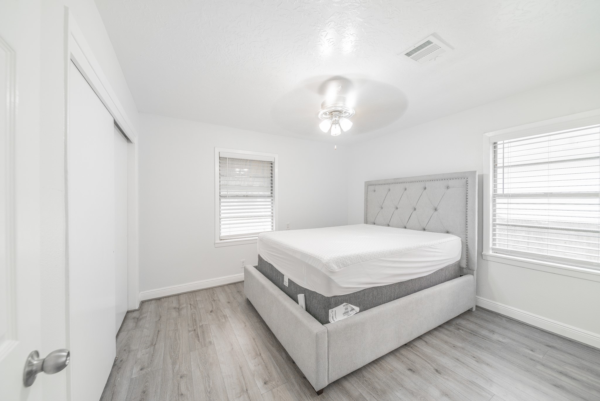 415 Gober Street Houston, TX 77017 - Photo 10 of 12 a white bed sitting in a bedroom next to a window and a chandelier