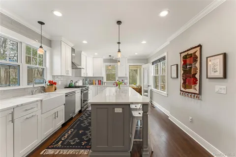 a large kitchen with stainless steel appliances kitchen island granite countertop a stove and a sink