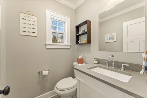 a bathroom with a granite countertop toilet sink and mirror