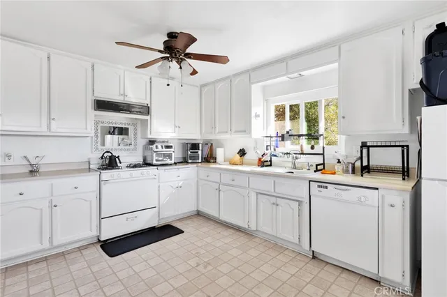 a kitchen with white cabinets and white appliances