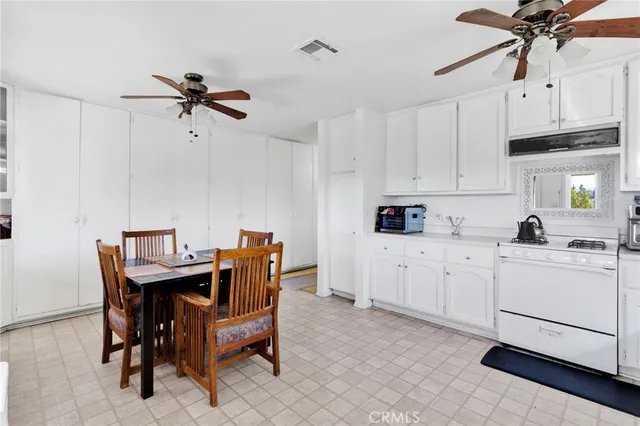 a kitchen with stainless steel appliances white cabinets and wooden floor