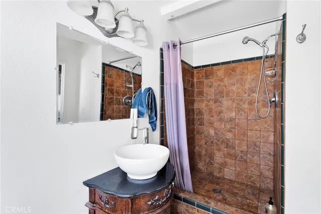 a bathroom with a shower a sink and a mirror