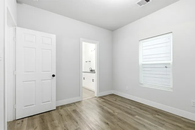 an empty room with wooden floor and window
