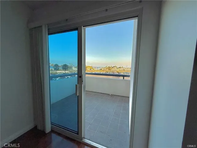 a view of an empty room with wooden floor and window