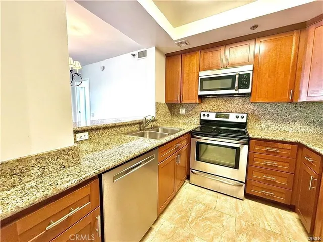 a kitchen with granite countertop a refrigerator and a sink