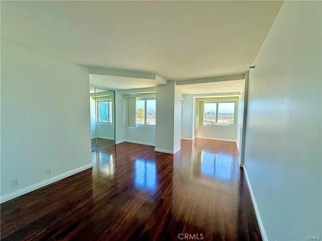 a room with wooden floor and windows