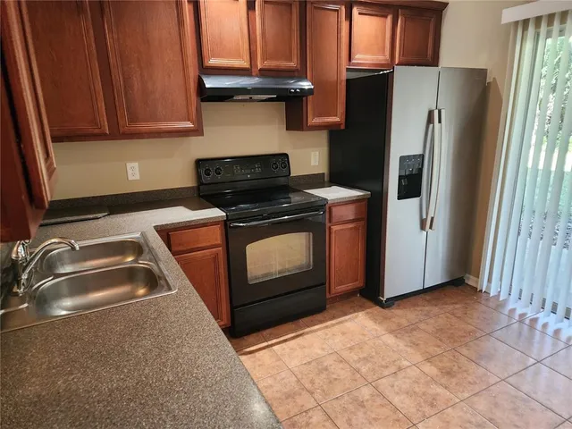 a kitchen with stainless steel appliances granite countertop a stove a refrigerator and a sink