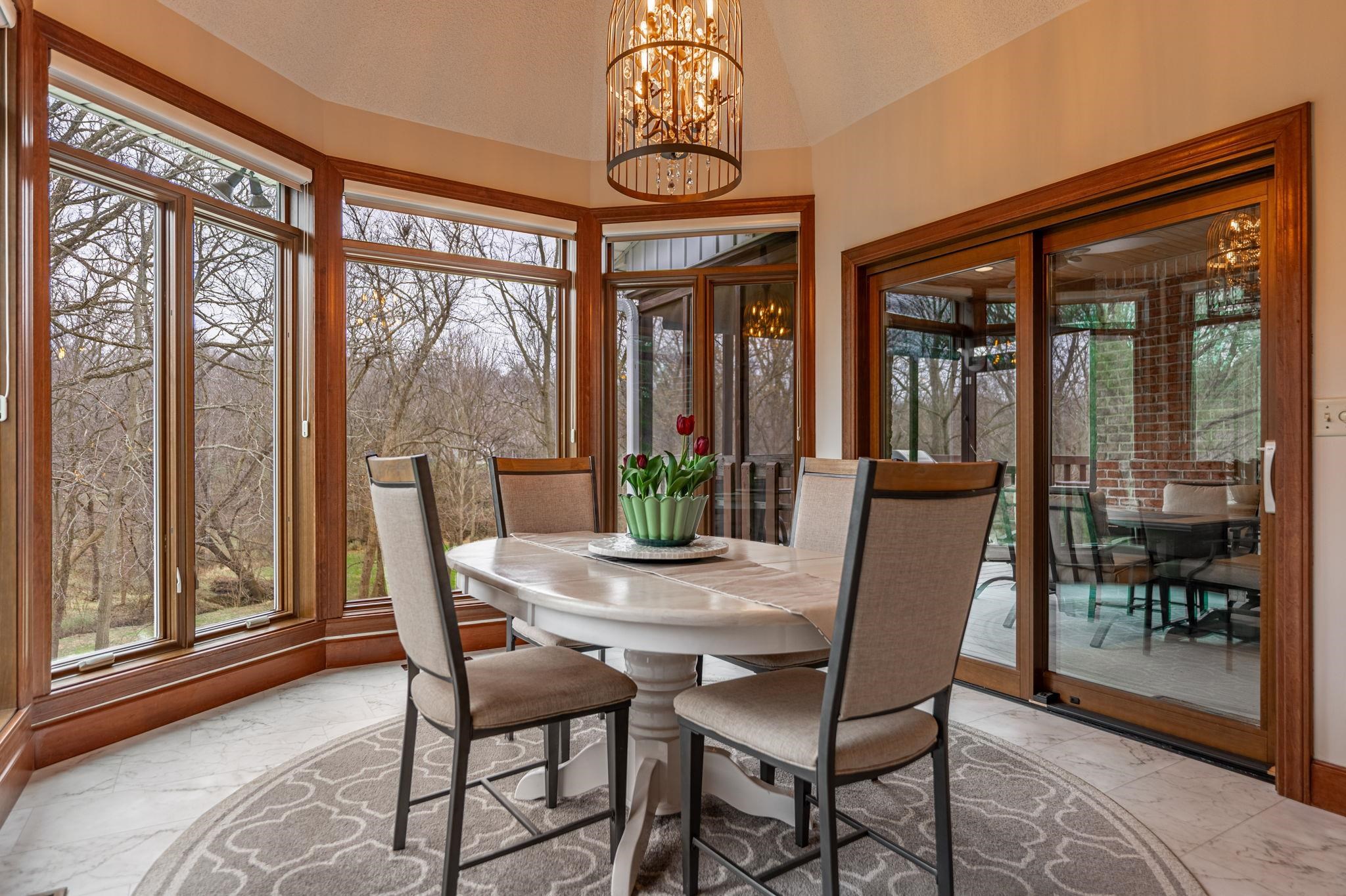 8161 Killarney Aire Road Roscoe, IL 61073 - Photo 16 of 53 a dining room with furniture large windows and a chandelier
