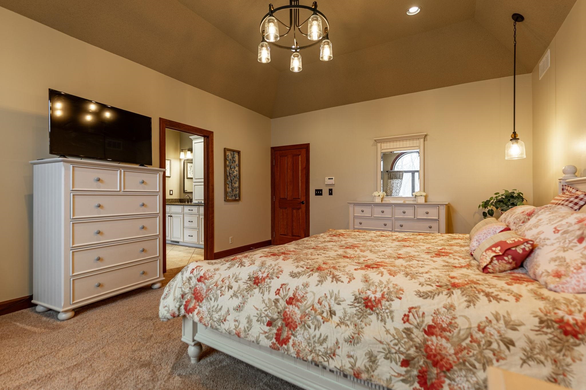 8161 Killarney Aire Road Roscoe, IL 61073 - Photo 21 of 53 a bedroom with a large bed and a flat tv screen on dresser