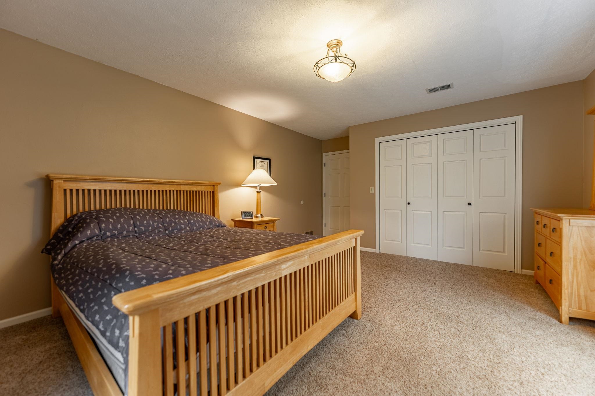 8161 Killarney Aire Road Roscoe, IL 61073 - Photo 36 of 53 a bedroom with a bed and a chandelier