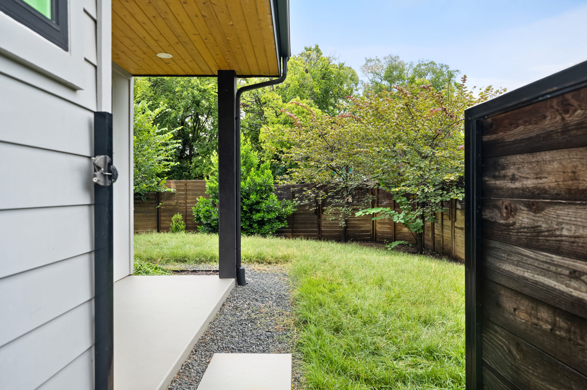 3508 Lyons Road Austin, TX 78702 - Photo 32 of 40 A fenced backyard offers a private retreat with lush greenery and a wood-slatted gate.
