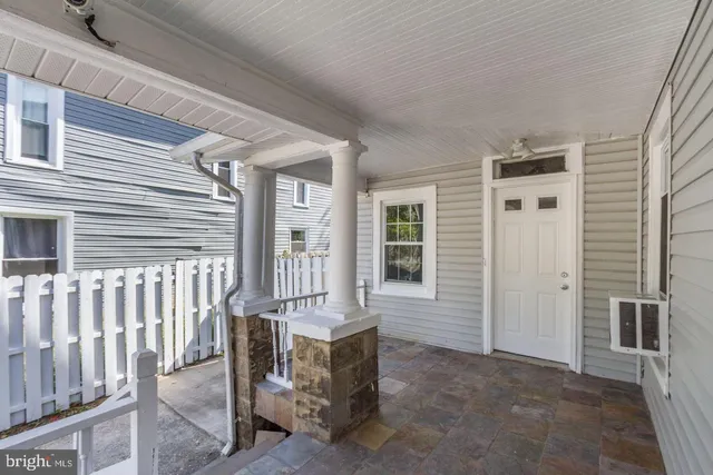 a view of a house with a chairs and table in a patio