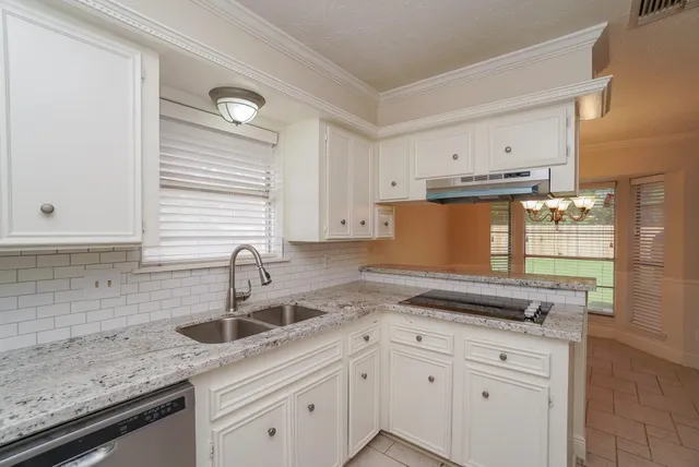 a kitchen with granite countertop a sink and cabinets