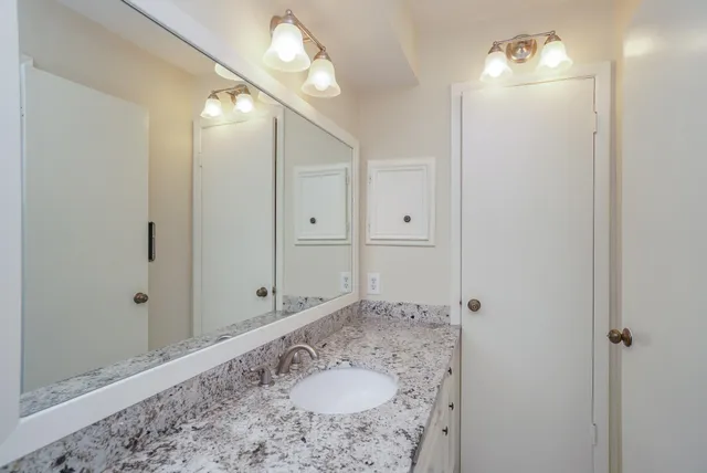 a bathroom with a sink vanity and shower