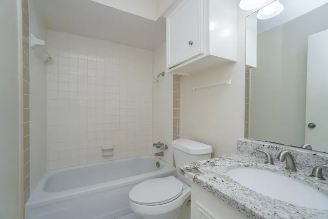a bathroom with a granite countertop sink toilet and shower