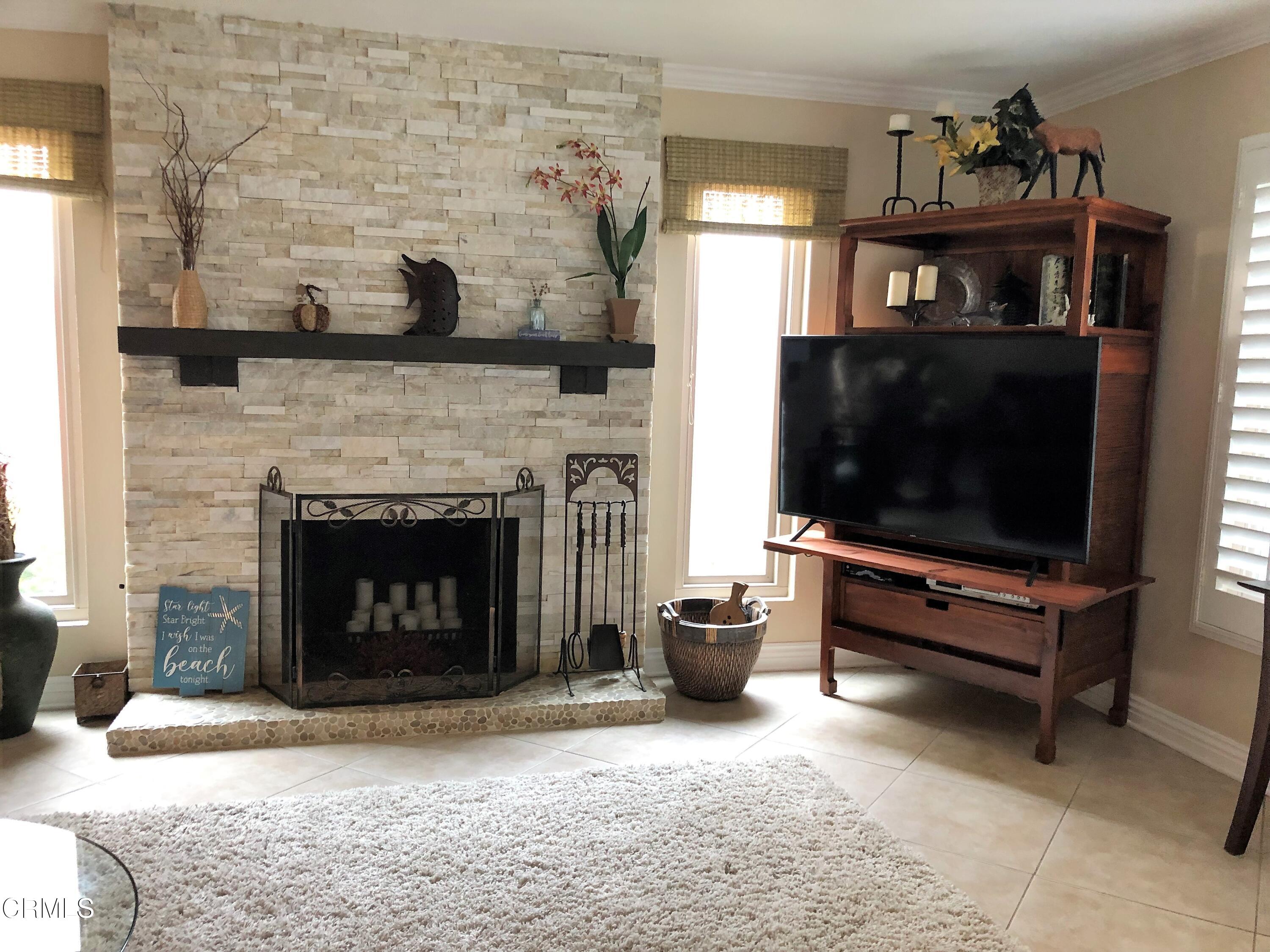 4962 Nautilus Street, Unit 1 Oxnard, CA 93035 - Photo 4 of 18 a living room with furniture a flat screen tv and a fireplace
