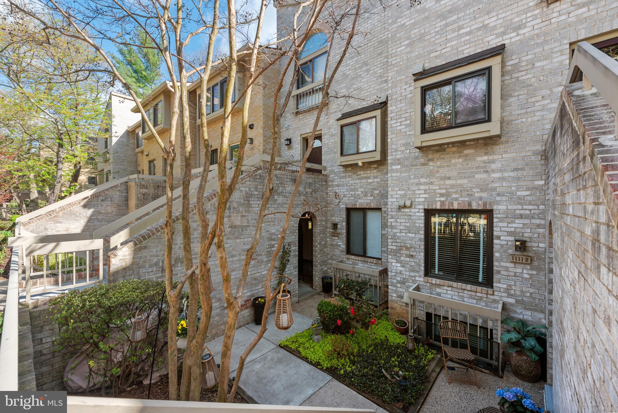11116 Boathouse Court, Unit 93 Reston, VA 20191 - Photo 2 of 34 a view of a brick house with a yard and potted plants