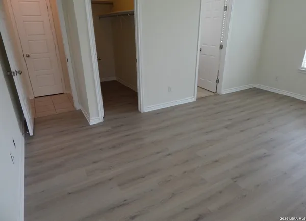 a view of an empty room with wooden floor