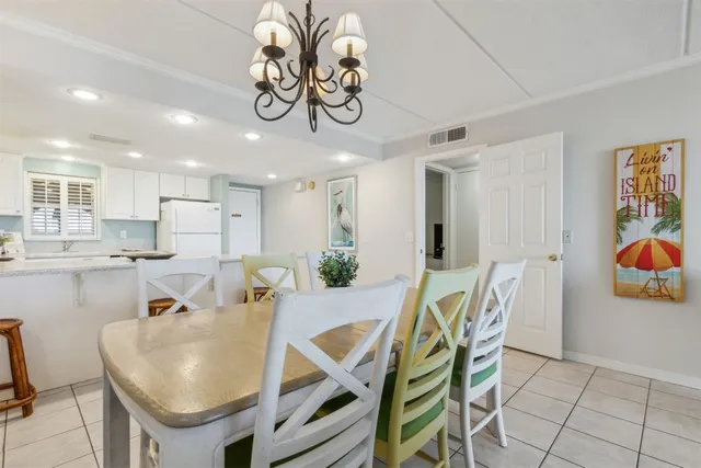 a dining room filled chandelier and kitchen view