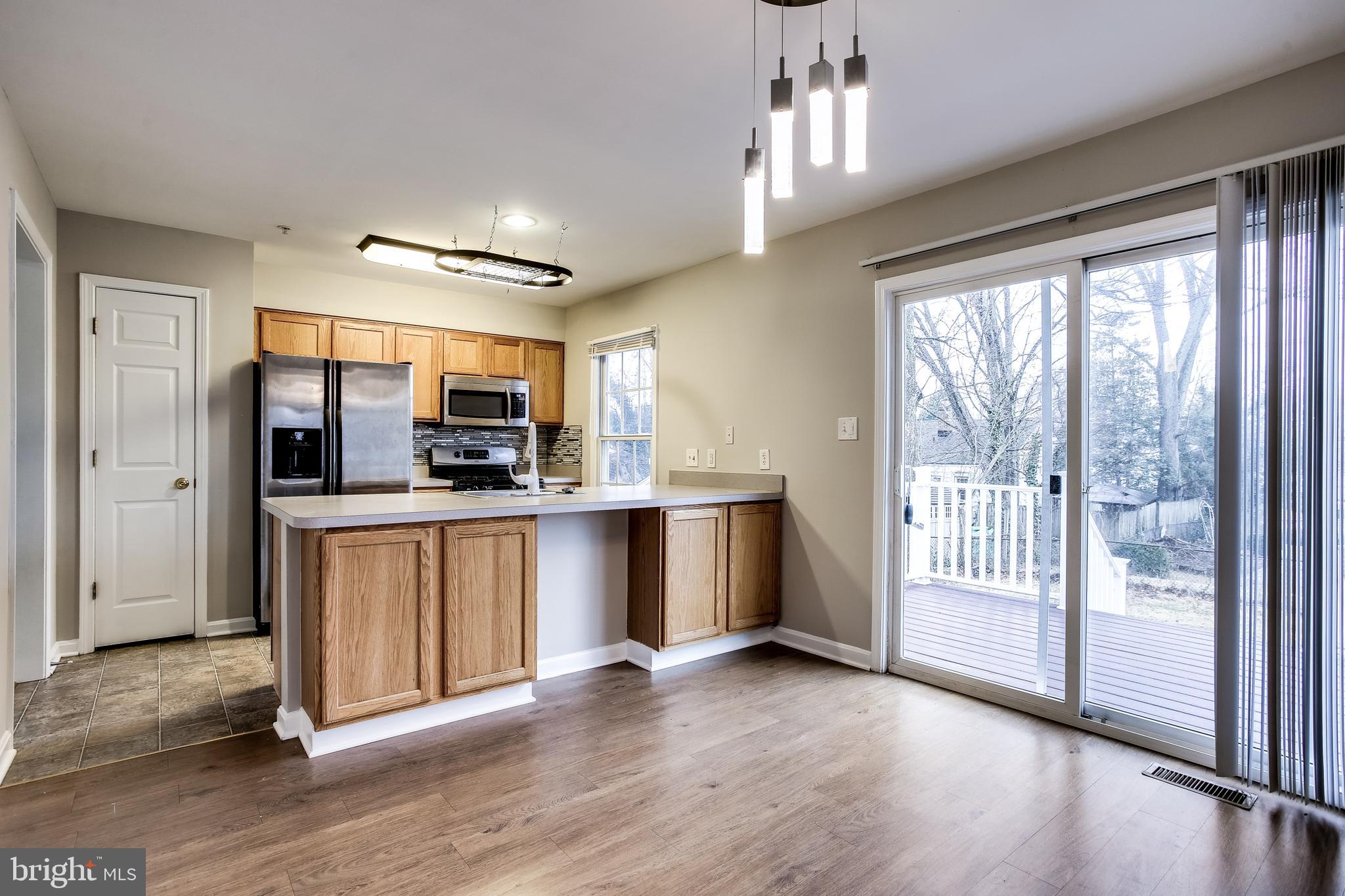 11506 Joseph Mill Road Silver Spring, MD 20906 - Photo 5 of 29 a large kitchen with stainless steel appliances granite countertop a large window and a refrigerator