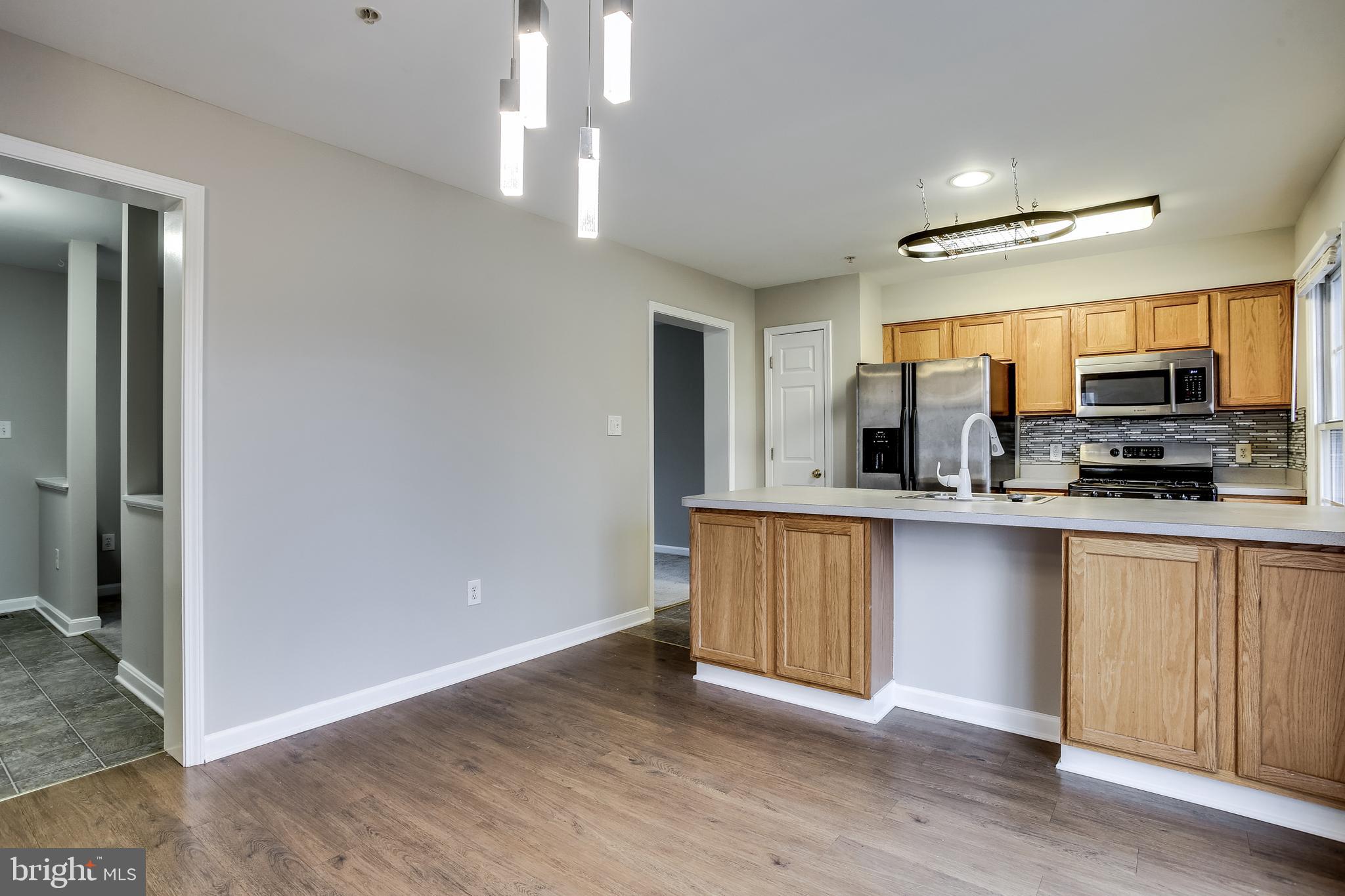 11506 Joseph Mill Road Silver Spring, MD 20906 - Photo 6 of 29 a kitchen with stainless steel appliances granite countertop a stove a sink and a refrigerator with wooden floors