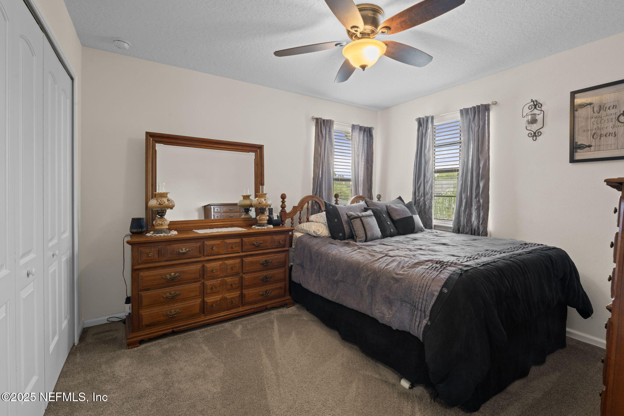 203 Buck Run Way St. Augustine, FL 32092 - Photo 36 of 62 a bedroom with a bed and a chandelier