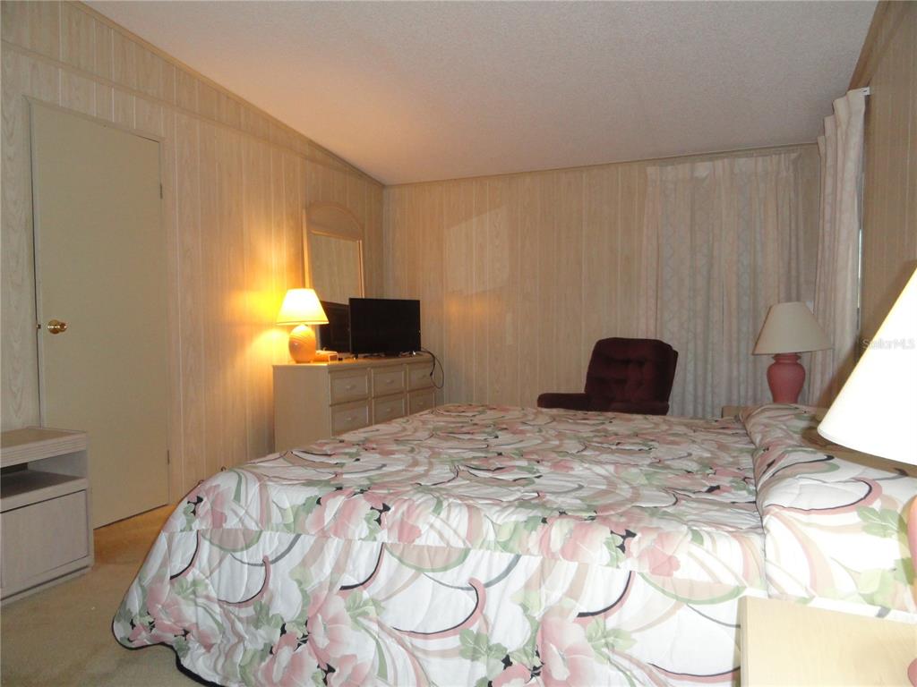 6233 Parakeet Road Englewood, FL 34224 - Photo 18 of 27 a bedroom with a bed and wooden floor