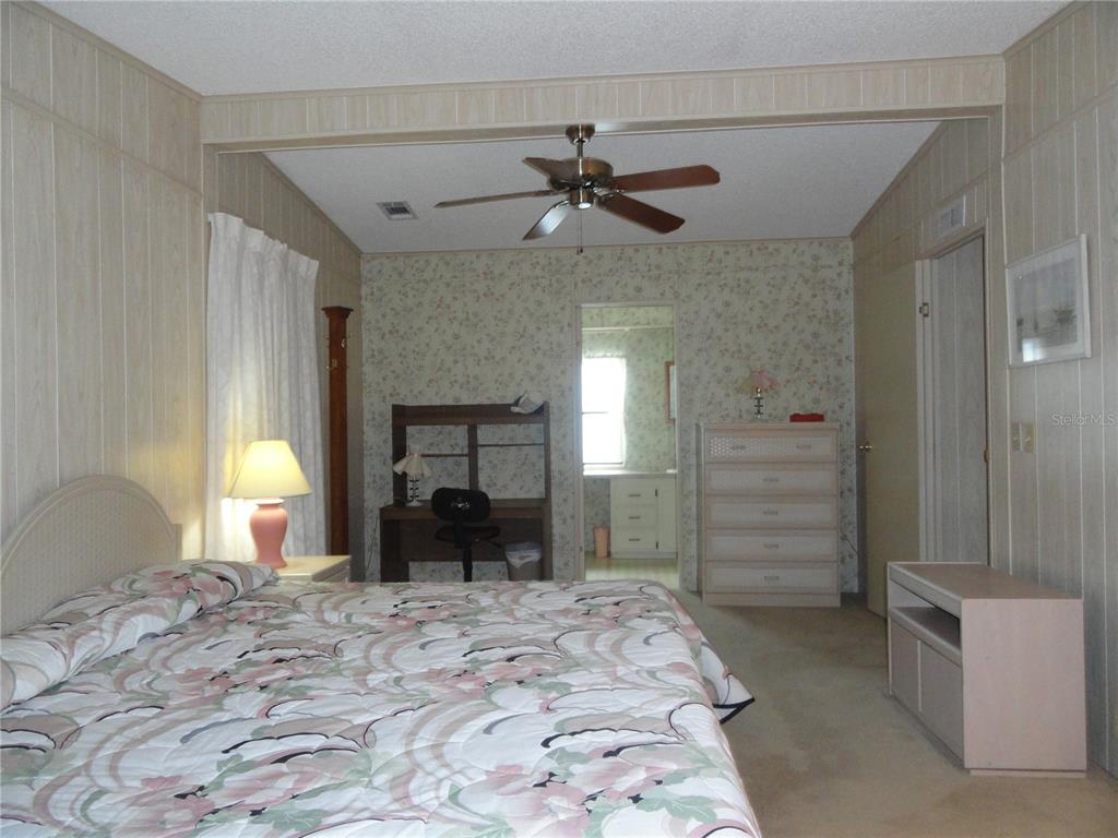 6233 Parakeet Road Englewood, FL 34224 - Photo 21 of 27 a bedroom with a bed and a chandelier