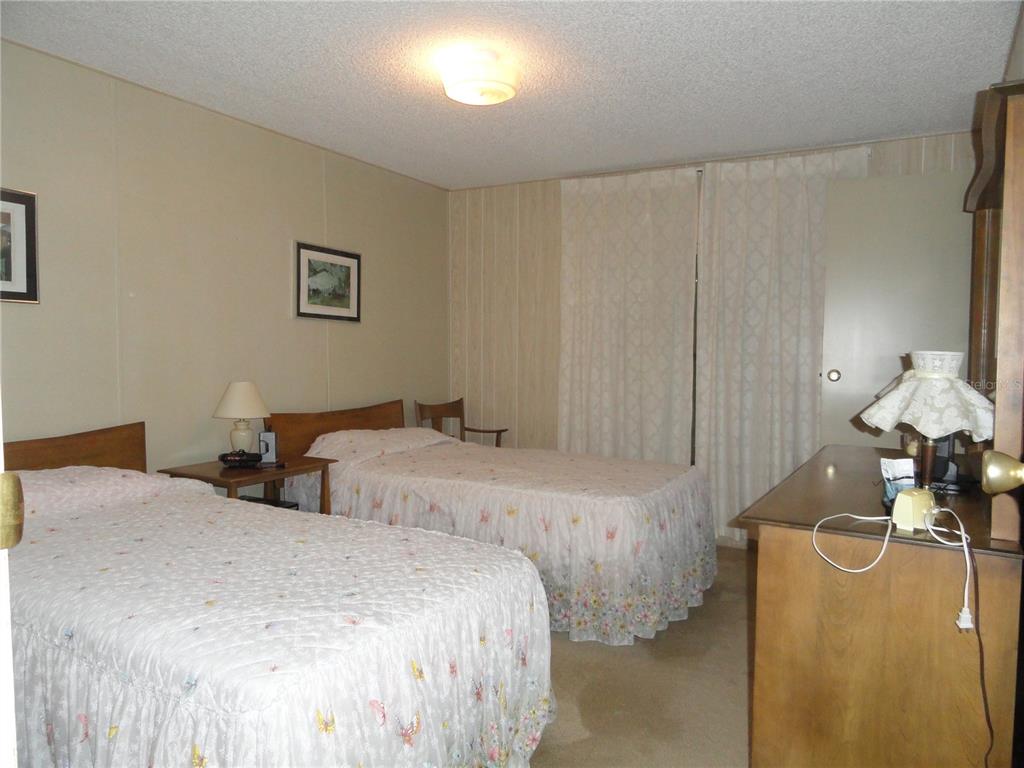 6233 Parakeet Road Englewood, FL 34224 - Photo 23 of 27 a bedroom with two bed and a chandelier