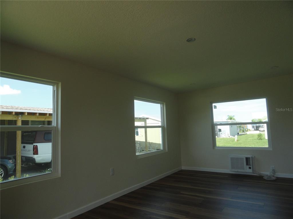 6233 Parakeet Road Englewood, FL 34224 - Photo 24 of 27 an empty room with wooden floor and windows