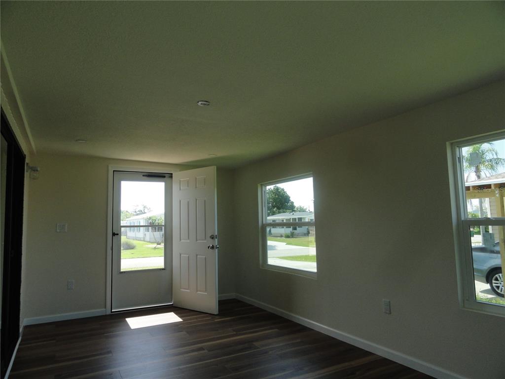 6233 Parakeet Road Englewood, FL 34224 - Photo 25 of 27 an empty room with wooden floor and windows