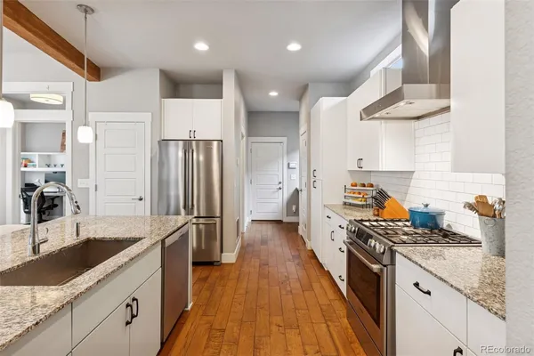 a kitchen with granite countertop a sink stove and refrigerator