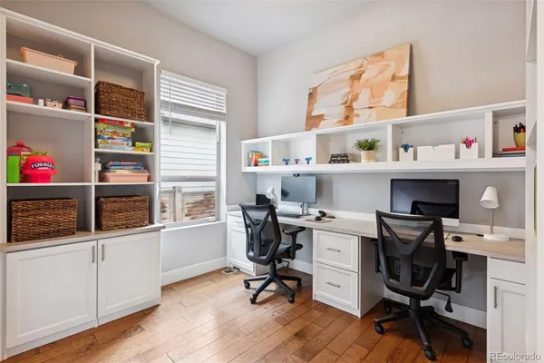 a view of a workspace with furniture and a window