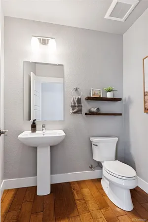 a bathroom with a toilet a sink and mirror