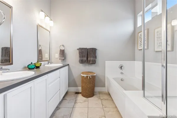a bathroom with a tub sink and mirror