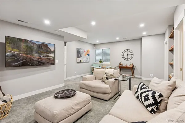 a living room with furniture and a wall painting