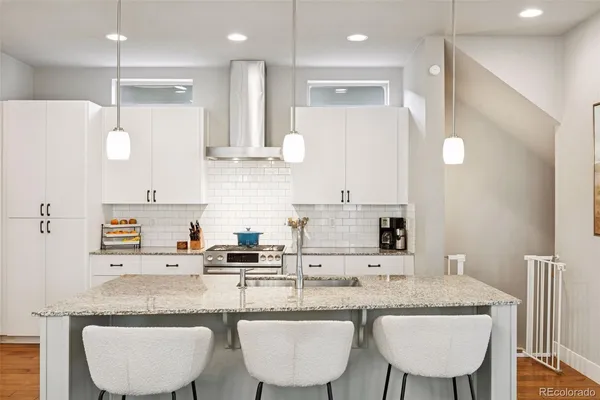 a kitchen with granite countertop a sink and white cabinets