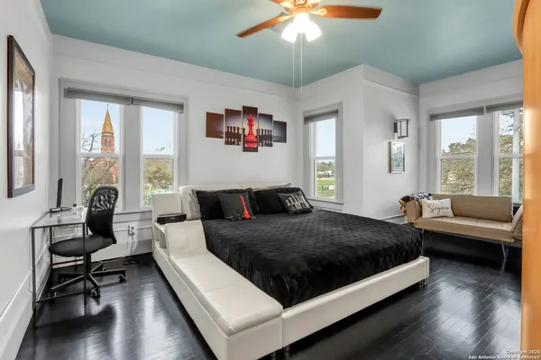 a bedroom with a bed a chandelier and a window