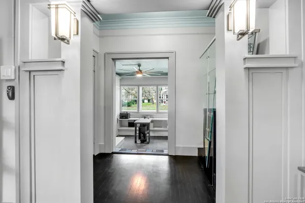 a view of a hallway with wooden floor and dining room view