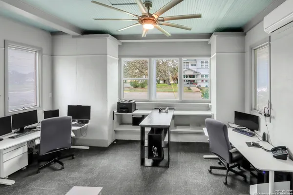 a view of a workspace with furniture and a window