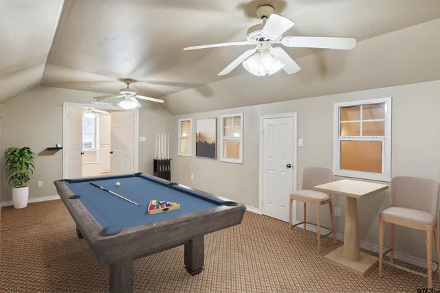 a room with chandelier fan and windows