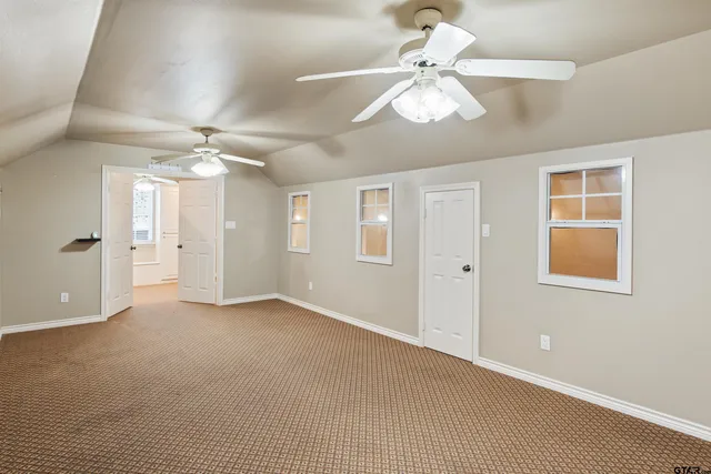 a view of an empty room with a chandelier fan