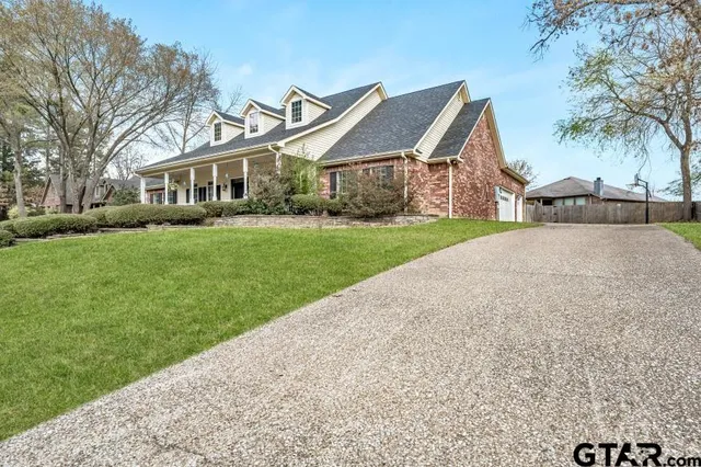 a front view of a house with a garden and trees