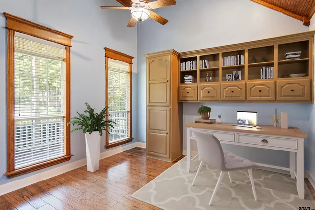 a dining room with wooden floor and windows