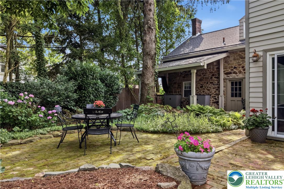 2014 Linden Street Bethlehem, PA 18017 - Photo 64 of 85 An inviting stone patio offers a private outdoor retreat, surrounded by vibrant plantings and mature trees.