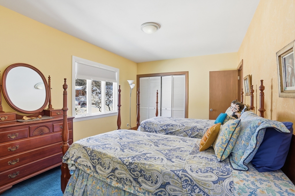 17 North Street Lexington, MA 02420 - Photo 21 of 42 a bedroom with a bed a mirror on dresser and a window