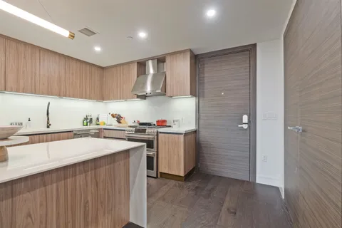 a kitchen with a sink a refrigerator and cabinets